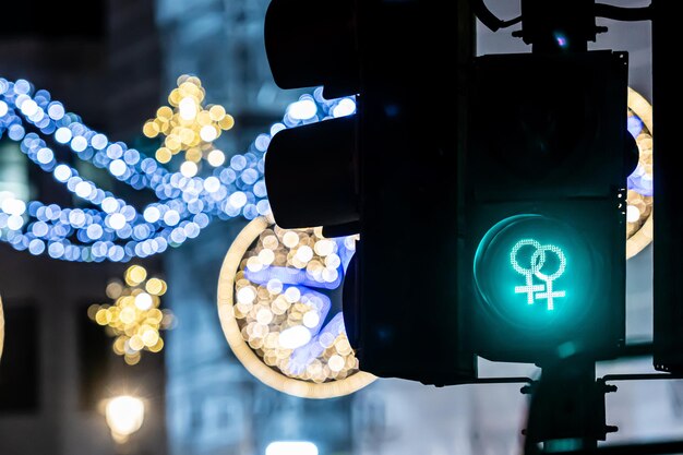 Photo pedestrian semaphore with green light and defocused christmas street decorations in the background