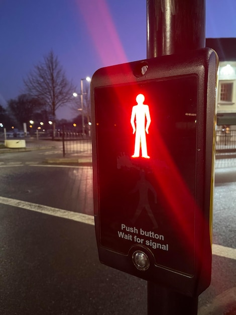 Pedestrian traffic lights glowing red on a crossroad