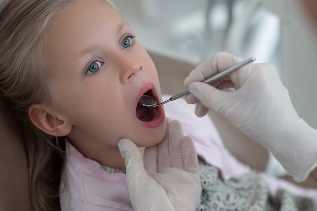 Pediadontist examining teeth of her cute small patient