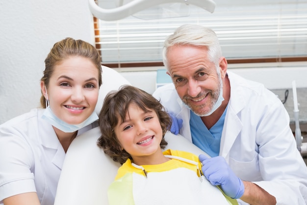 Pediatric dentist assistant and little boy all smiling at camera