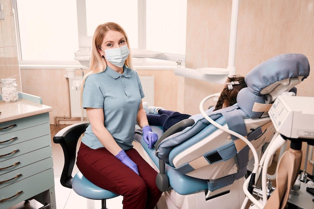 Pediatric dentist checking child teeth in dental office