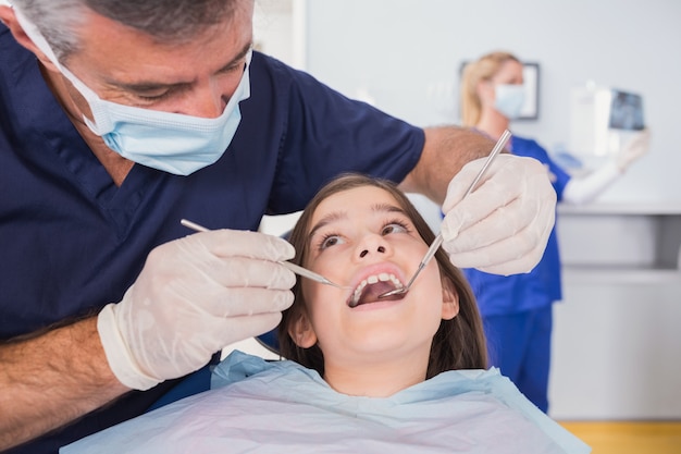 Dentista pediatrico che esamina il suo giovane paziente