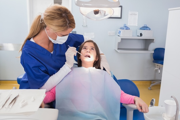 Pediatric dentist examining her young patient 