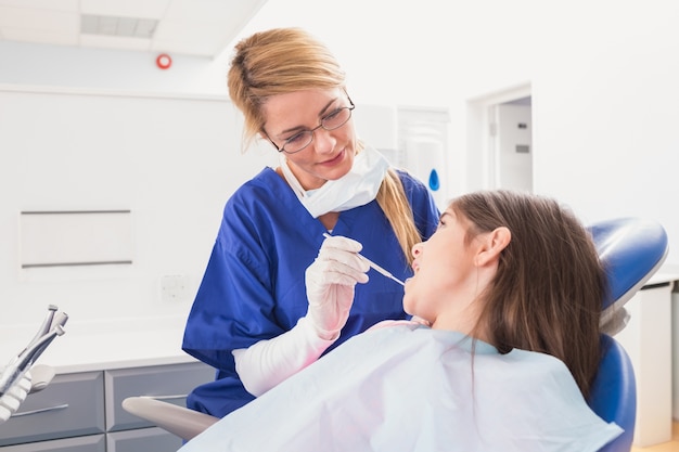 Pediatric dentist examining her young patient