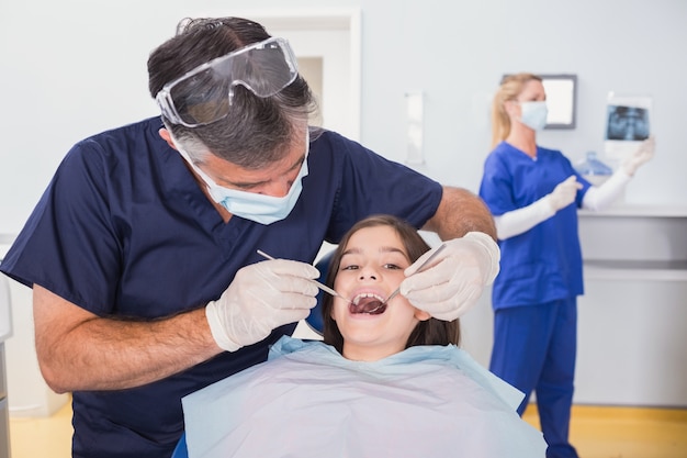 Pediatric dentist examining her young patient 