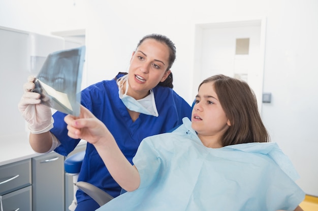 Pediatric dentist explaining to young patient the x-ray