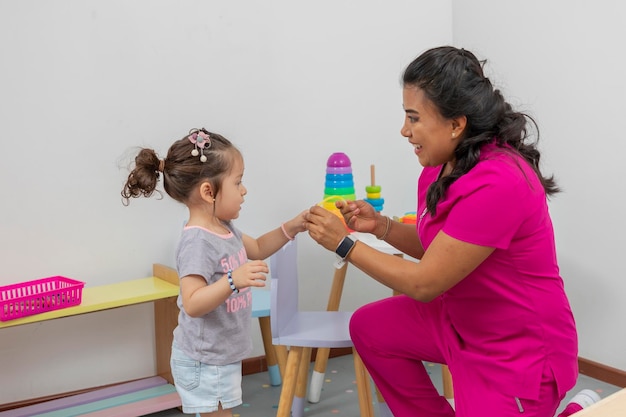 Pediatric doctor places a bracelet on a girl as a reward after the consultation she gave her