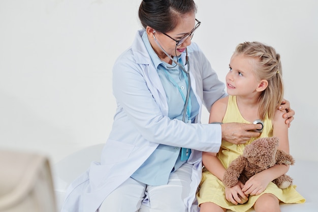 Pediatrician checking lung sounds