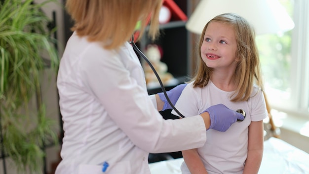 Pediatrician examines little girl with stethoscope health care and medical insurance concept