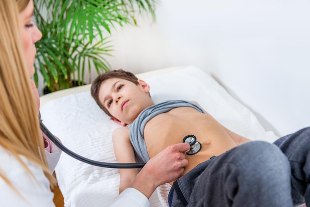 Pediatrician examining boy's abdomen