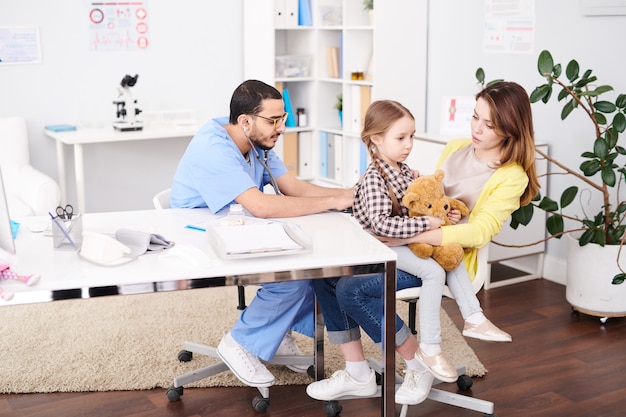 Pediatra examining little child