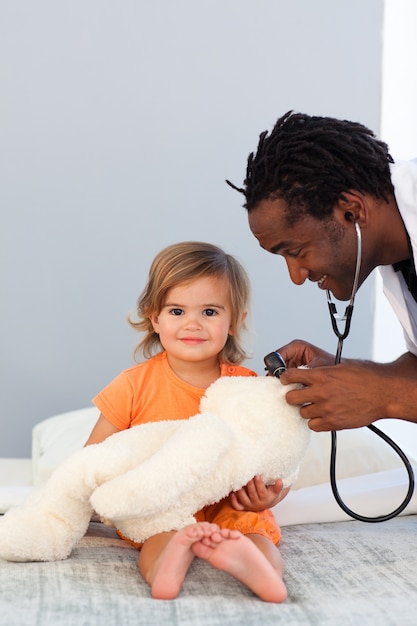 Pediatrician exams a little girl with stethoscope