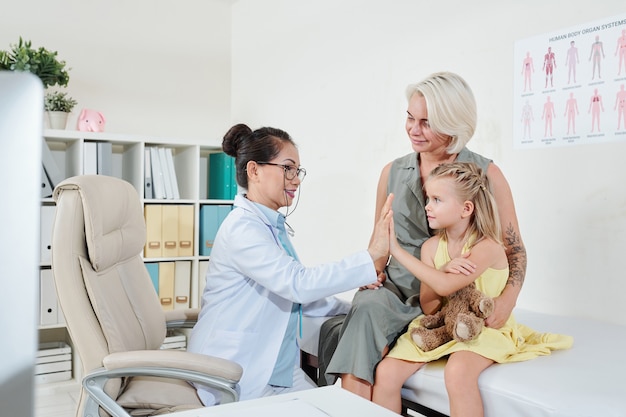 Pediatrician giving his little patient high five