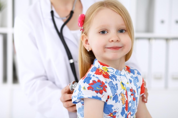 Pediatrician is taking care of baby in hospital Little girl is being examine by doctor by stethoscope Health care insurance and help concept