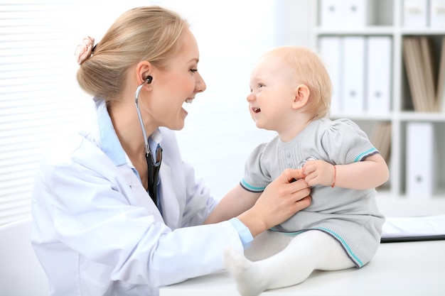 Pediatrician is taking care of baby in hospital Little girl is being examine by doctor with stethoscope