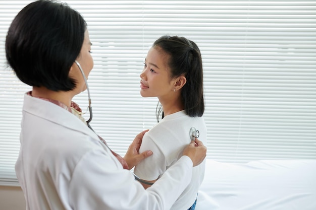 Photo pediatrician listening breath sounds