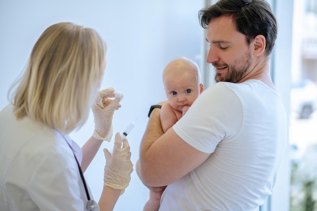 Pediatrician preparing to administer an injection to a newborn