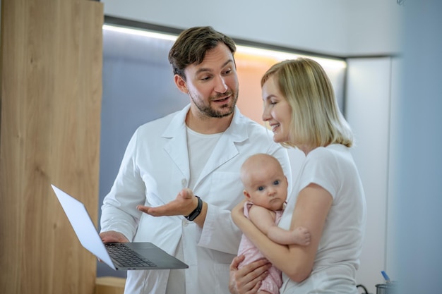 Pediatrician receiving a woman with the neonate in his office