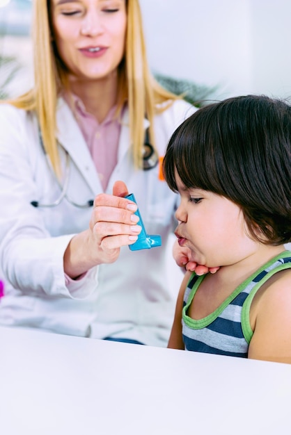 Pediatrician using asthma inhaler for little boy