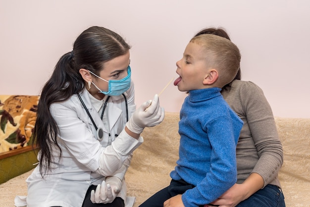 Pediatrician woman examining baby's throat in clinic