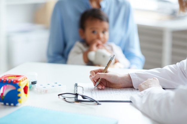 Photo pediatrician writing prescription