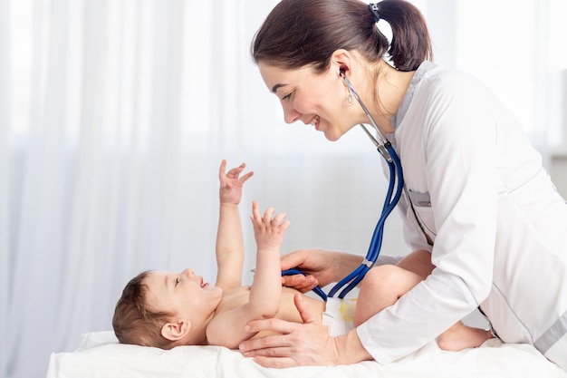 pediatrics a doctor examines a baby boy and uses a stethoscope to listen to the babys heartbeat or breathing the concept of medicine and health