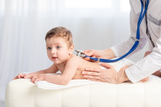 Pediatrics, a doctor examines a baby boy and uses a stethoscope to listen to the child's breathing, the concept of medicine and health