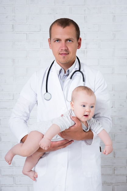 Photo pediatry concept - doctor pediatrician holding little baby patient in hospital