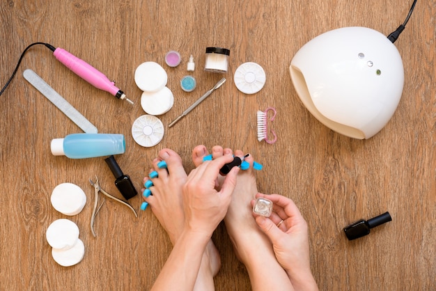 Pedicure at home using nail Polish and UV lamps, nail files and scissors. taking care of yourself and your appearance from the comfort of your home. the process of paint nails.