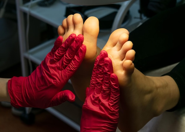 Foto il maestro di pedicure massaggia i piedi dei pazienti