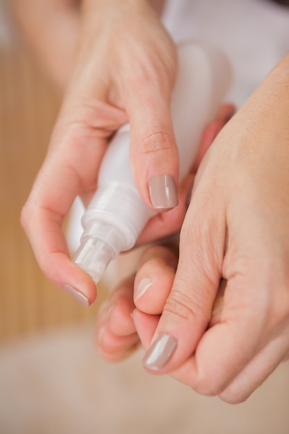 Pedicurist cleaning feet with spray