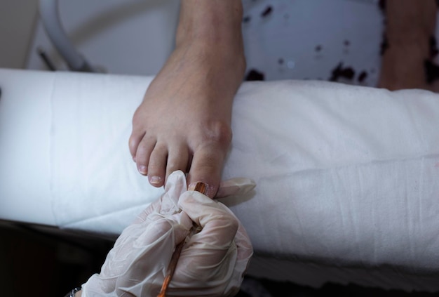 Photo pedicurist's hands in protective rubber gloves filing toenails