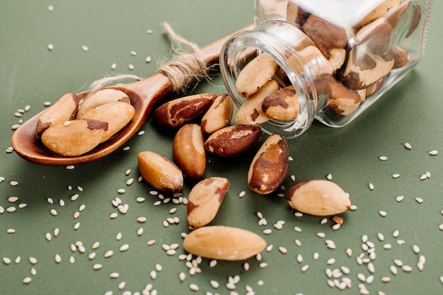 Peeled Brazil nuts scattered on a green background