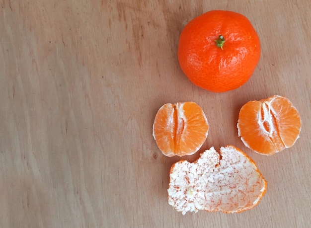 Peeled clementines on a wooden background Copy space photo