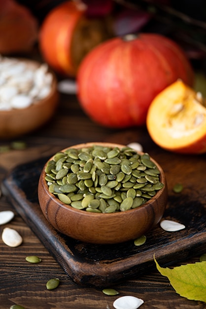 Peeled dried pumpkin seeds in a wooden bowl on the table