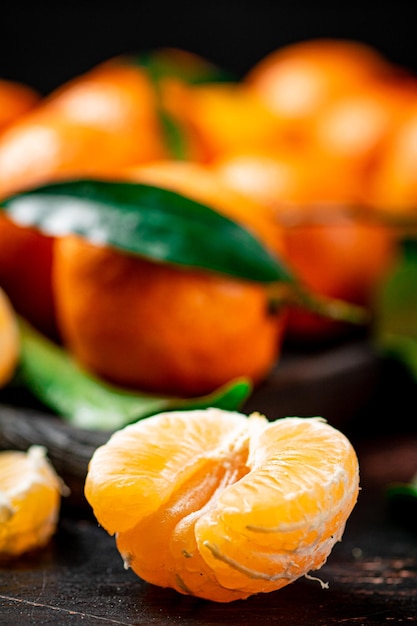 Foto mandarini freschi sbucciati su un fondo nero