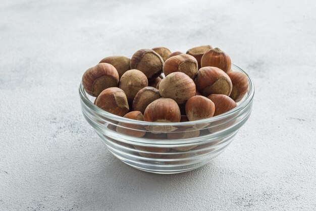 peeled hazelnuts in a bowl on white background