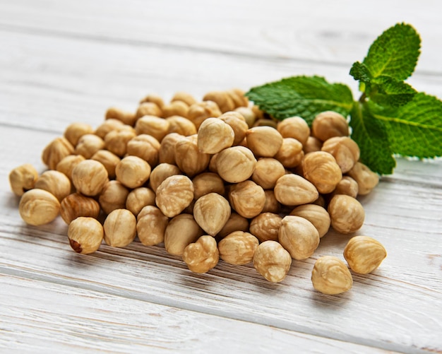 Peeled hazelnuts on a  white wooden background