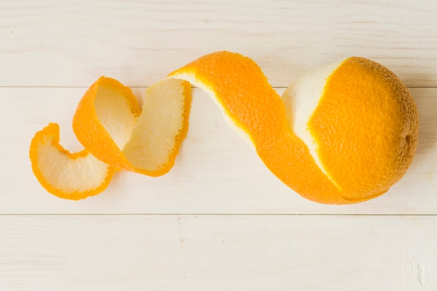 Peeled orange fruit on wooden background