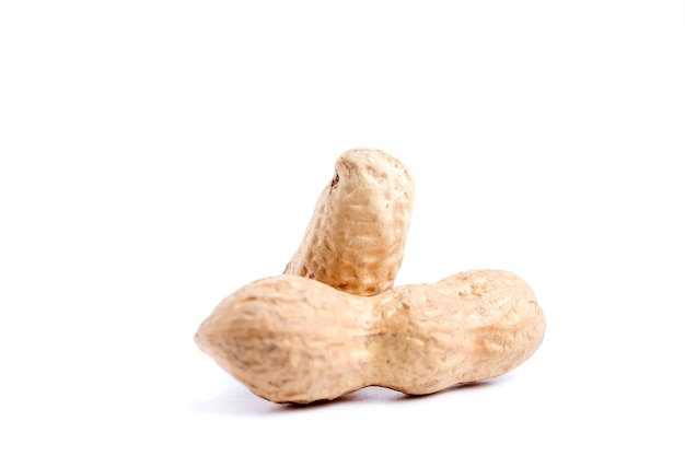 Peeled peanuts and peanut pod isolated on white wall.