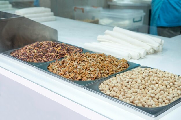 Peeled pistachios walnuts hazelnuts and nougat for making nougat rolls on the counter in a candy s