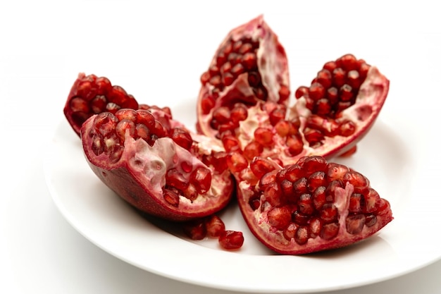 Peeled pomegranate on a white background in a plate