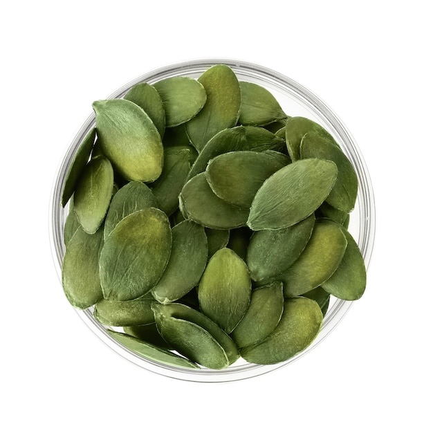 Peeled pumpkin seeds in glass bowl isolated on white top view