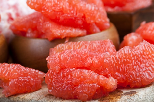 Peeled red grapefruit divided into slices during cooking, juicy citrus grapefruit