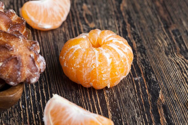 Peeled ripe juicy tangerine on a wooden table