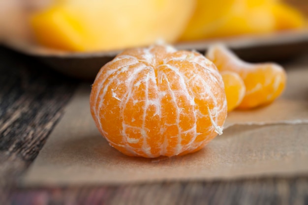 Peeled ripe juicy tangerine on a wooden table