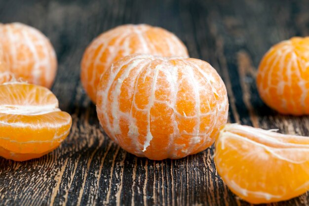 Peeled ripe juicy tangerine on a wooden table