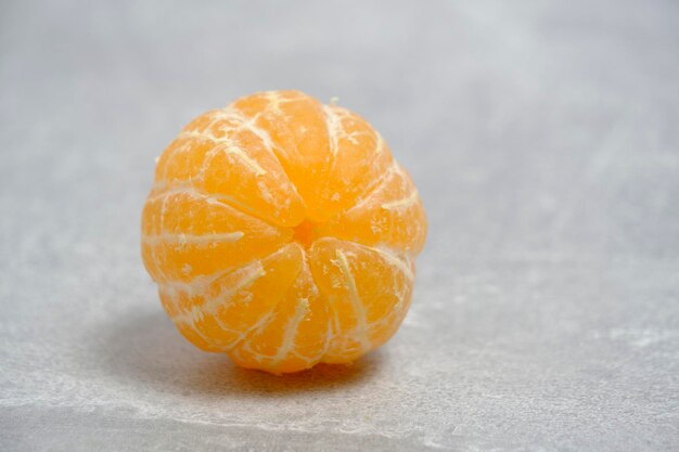 Photo peeled ripe tangerine gray concrete background