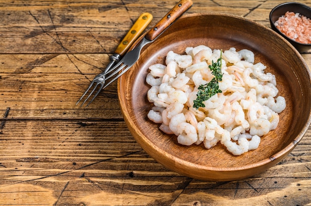 Peeled Shrimps, Prawns in a wooden bowl. wooden table. top view.