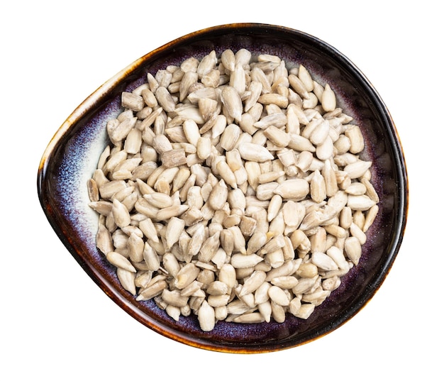 Peeled sunflower seeds in ceramic bowl isolated